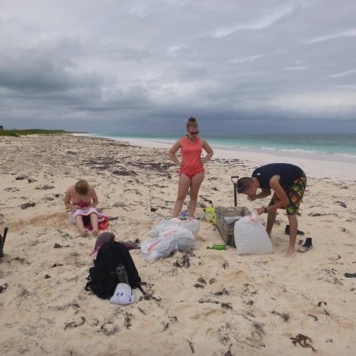 Students cleaning up trash on a beach in the Bahamas